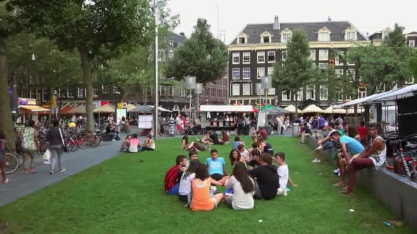 Människor avkopplande på en äng på Rembrandt-torget — Stockvideo