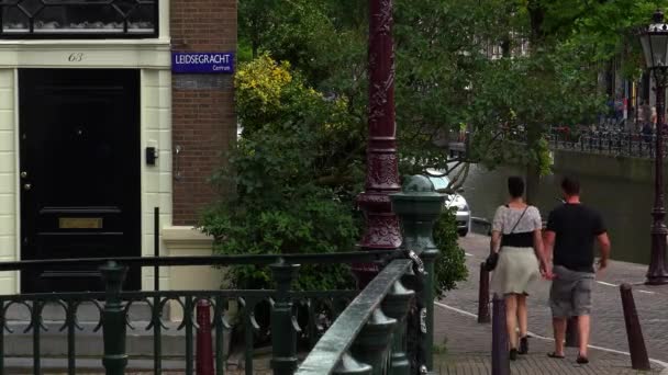 Casal caminhando pela área do canal em Amsterdã em Leidsegracht — Vídeo de Stock