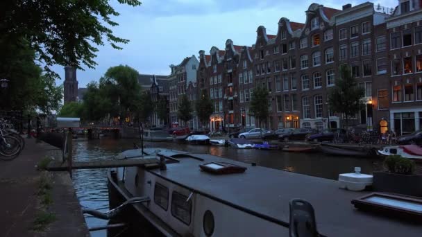Здания в Амстердаме на канале вечером — стоковое видео