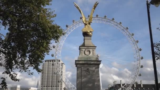 London Eye detrás de una estatua de oro - LONDRES, INGLATERRA — Vídeos de Stock