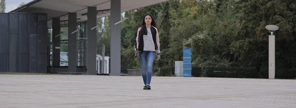 Mujer asiática joven camina sobre una plaza en una ciudad — Foto de Stock