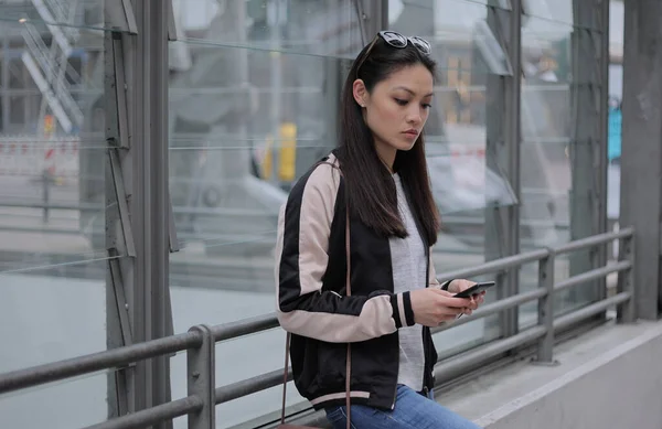 Giovane donna asiatica scrive messaggi di testo sul suo telefono — Foto Stock