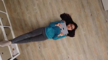 Genç ve güzel bir kadın yere uzanıp film izliyor.