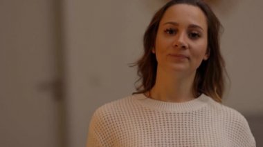 20 'li yaşlarının ortasında güzel bir kadın kameraya gülümsüyor.