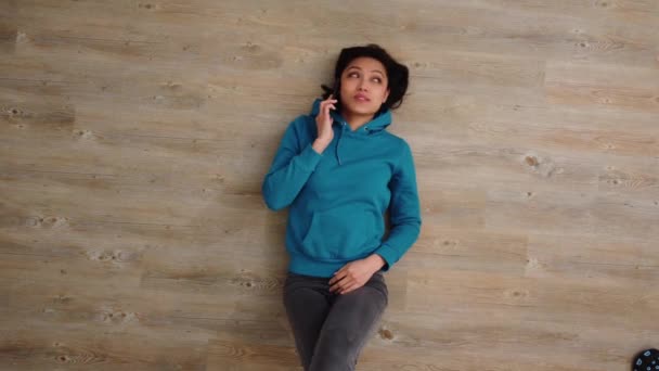 Young woman lies on the floor and makes phone calls — Stock Video