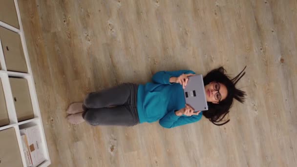 Mladá hezká žena leží na podlaze a sleduje filmy — Stock video