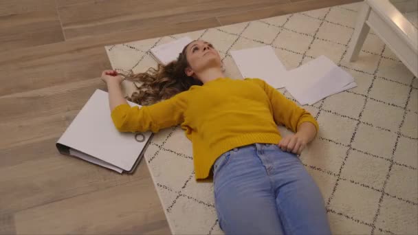 Mujer joven agotada por el trabajo tendida en el suelo — Vídeo de stock