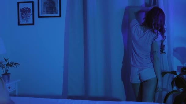 Junge Frau wacht im Bett auf — Stockvideo