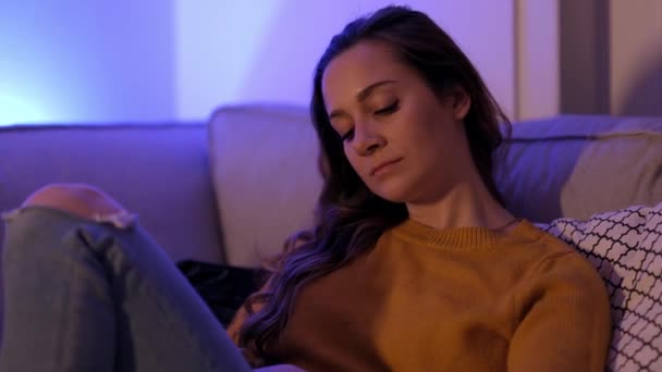 젊은 여자는 집 소파에서 지루 해 한다 — 비디오