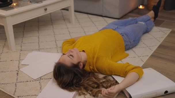 Junge Frau liegt erschöpft von der Arbeit auf dem Boden — Stockvideo