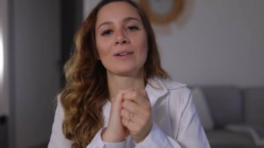 Video konferansındaki genç kadın kameraya konuşuyor.