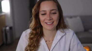 Video konferansındaki genç kadın kameraya konuşuyor.