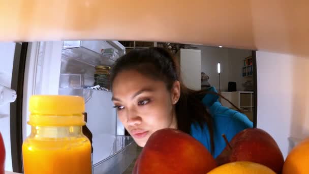 Giovane donna cerca cibo e bevande in frigorifero — Video Stock