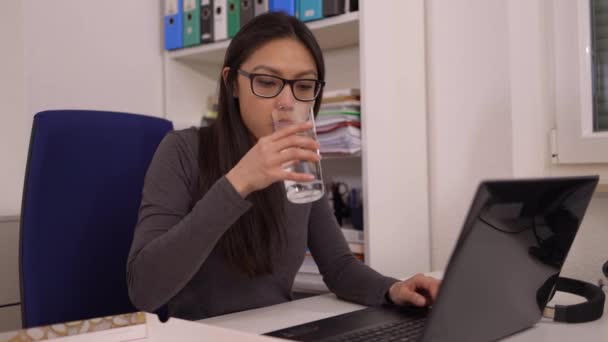 Mujer joven come una pizza del servicio de entrega mientras está en el trabajo — Vídeos de Stock