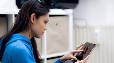 Genç bir kadın tablet bilgisayarla çalışıyor.