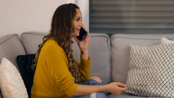 Mladá žena na telefonu doma ve svém bytě — Stock fotografie