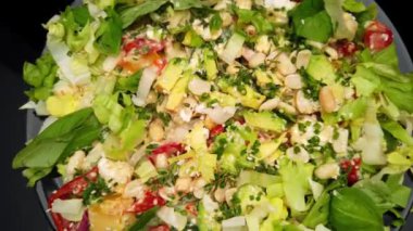 Siyah ahşap masada peynirli ve sebzeli salata. 