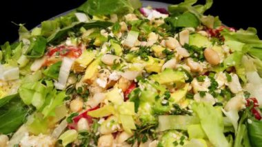 Siyah ahşap masada peynirli ve sebzeli salata. 