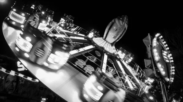 Carousels at amusement fair at night in black and white — Stock Photo, Image