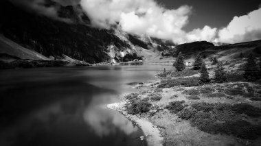 İsviçre Alplerindeki harika bir dağ gölünün üzerinden uçmak - T Gölü siyah beyaz