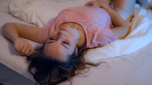 Молодая красивая женщина лежит ленивая на кровати — стоковое фото