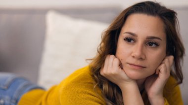 Evindeki kanepede rahat genç bir kadın.