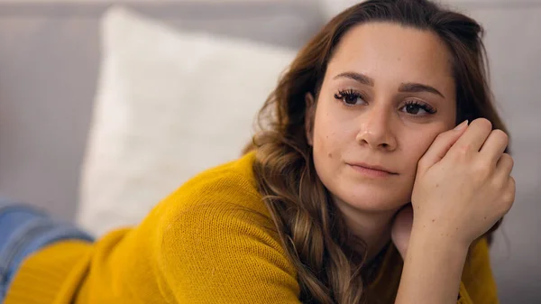 Jovem mulher relaxada no sofá em seu apartamento — Fotografia de Stock