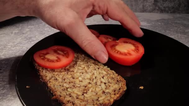 Cubra uma parte de pão com partes de tomates — Vídeo de Stock