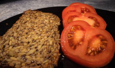 Tam teşekküllü ekmek ve taze kesilmiş domates.