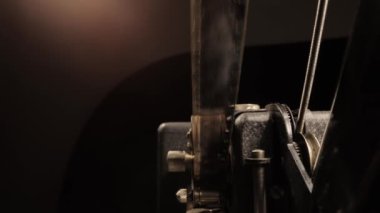 Yakın çekim görüntüsünde eski bir film projektöründen geçiyor.
