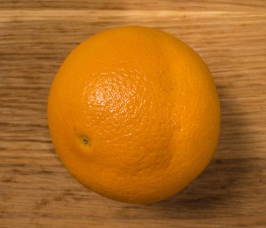 Tahta bir masada taze bir portakal.