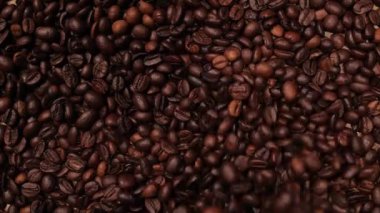 Kahve çekirdekleri masaya ağır çekimde düşüyor.