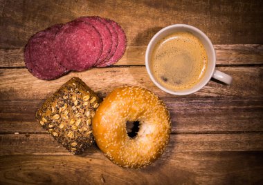 Sandviç, kahve ve sosisli kahvaltı masası.