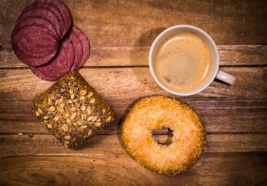 Sandviç, kahve ve sosisli kahvaltı masası.