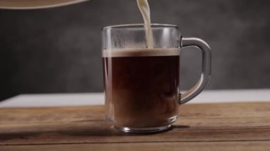 Taze demlenmiş bir fincan kahveye süt dök - yavaş çekim.