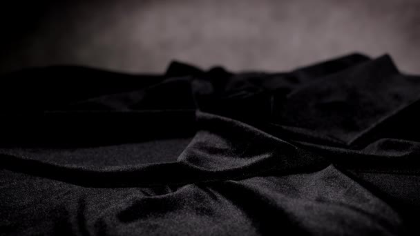 Red roses fall on a black velvet cloth in slow motion — Stock Video