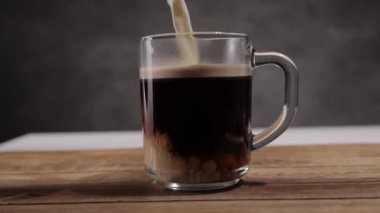 Taze demlenmiş bir fincan kahveye süt dök - yavaş çekim.