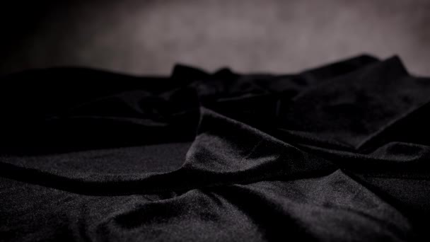 Red roses fall on a black velvet cloth in slow motion — Stock Video