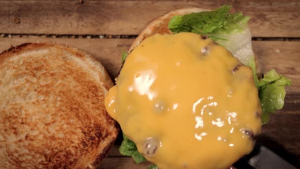 Menyiapkan burger keju dalam gerakan lambat - top down view — Stok Video