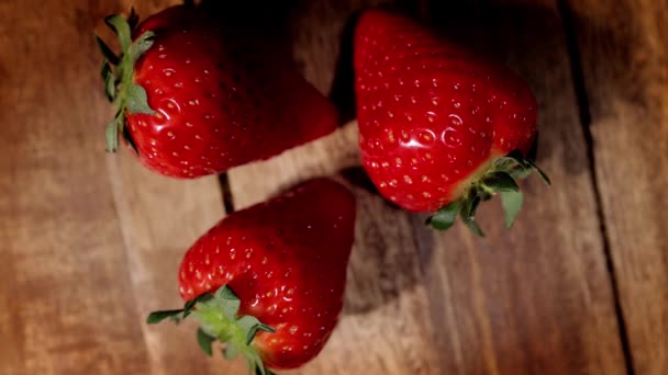 Aardbeien op een houten tafel in close-up — Stockvideo