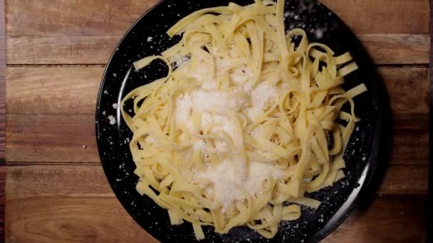 Посыпать сыр пармезан на тарелку пасты - замедленная съемка — стоковое видео