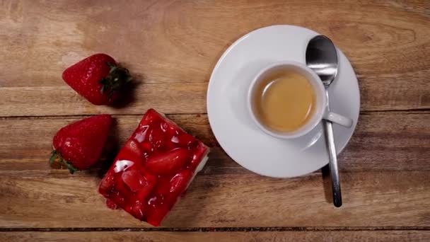 Un trozo de pastel de fresa con una taza de espresso — Vídeo de stock