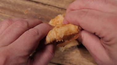 Yeni pişmiş bir kruvasanı yavaş çekimde parçalara ayır.