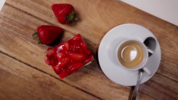 Un trozo de pastel de fresa con una taza de espresso — Vídeo de stock