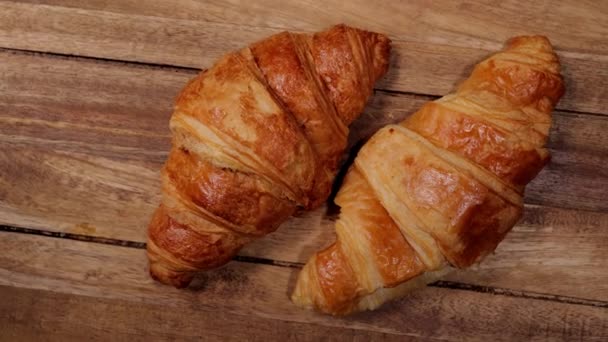 Two freshly baked French croissants on a wooden table — Stock Video