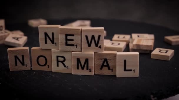 Слова New Normal написаны на деревянных кубиках букв — стоковое видео