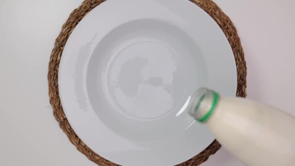 Häll mjölk på en tallrik - närbild — Stockvideo