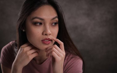 Düşünceli bir yüz ifadesi olan genç bir kadının yakın çekimi.