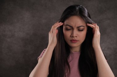 Genç kadın baş ağrısı çekiyor.