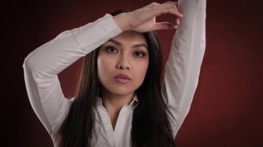 Kameraya poz veren genç Asyalı kadın.